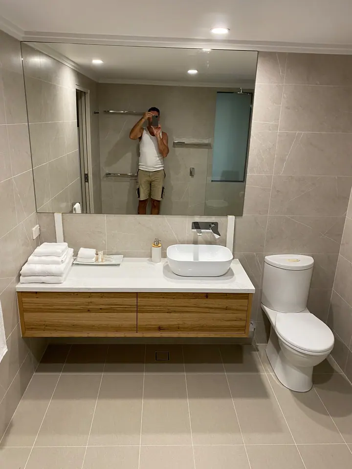 Bathroom with a timber floating vanity and large-format grey wall and floor tiles