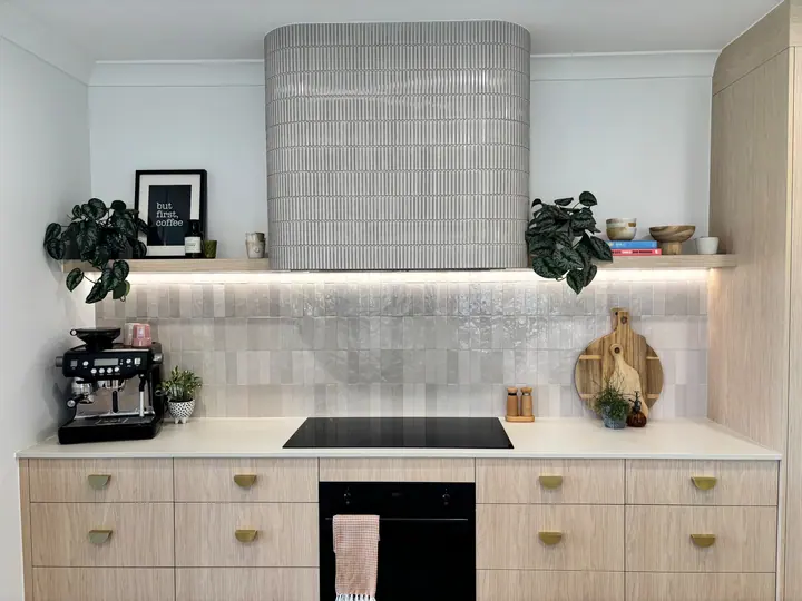 Kitchen rangehood clad in grey finger tiles above a handmade-look tiled splashback